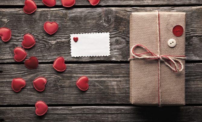 Vintage gift box with small hearts on wooden table.