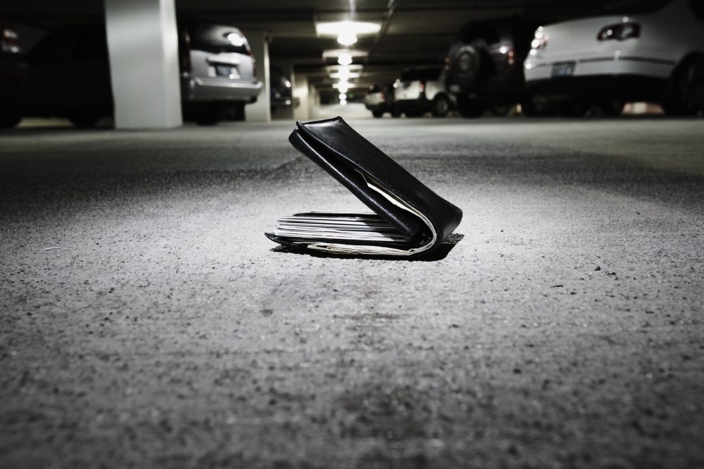 Wallet on concrete in parking garage (focus on wallet)