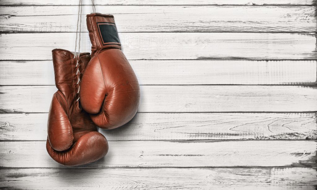 Boxing gloves hanging on wooden wall