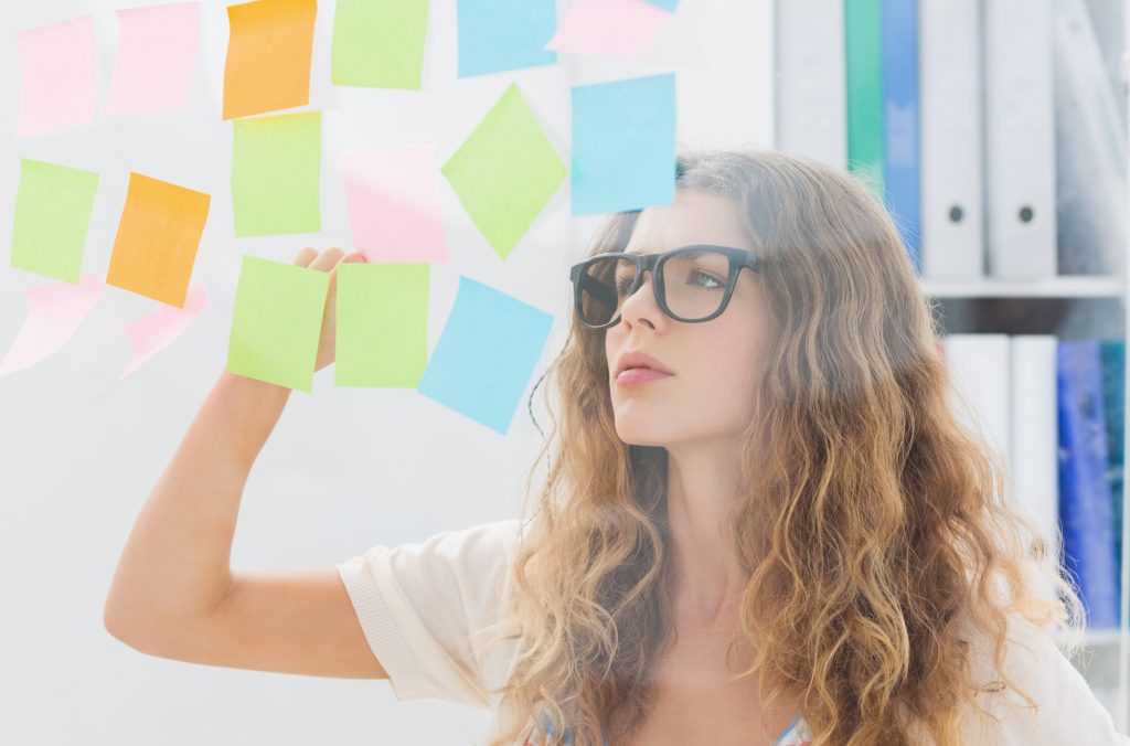 Concentrated artist looking at colorful sticky notes